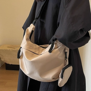 Large beige nylon crescent crossbody bag with adjustable strap and small coin pouch