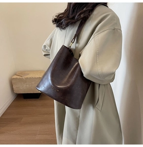 Detail of vintage dark brown bucket bag showing the texture and Fashion Bag print