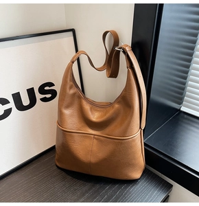 Dettaglio della borsa hobo marrone con trama in ecopelle e due tasche frontali esterne