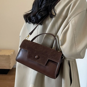 Coffee brown crossbody flap bag with textured leather panel on model in khaki coat