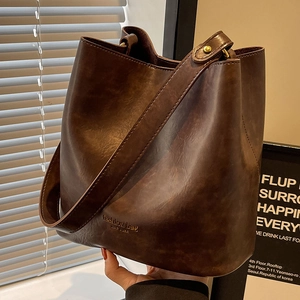 Deep brown retro bucket bag with adjustable shoulder strap and gold lettering detail
