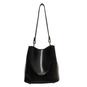 Classic black leather bucket bag with gold hardware and shoulder strap on white background