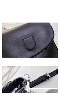 Detail of black leather texture bag with metal buckle and shield-shaped patch
