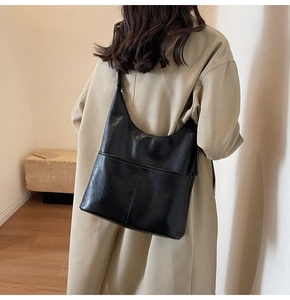 Dettaglio della borsa a secchiello hobo in pelle cerata nera con cuciture a griglia