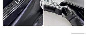 Close-up of silver metal zipper and chain detail on black leather crossbody bag
