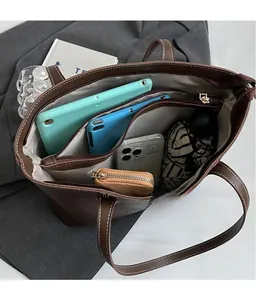 Interior view of brown tote bag with multi-compartment storage for tablets and essentials