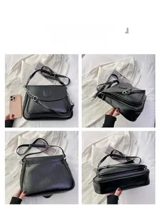 Detail view of black matte leather shoulder bag with silver chain and accordion layers