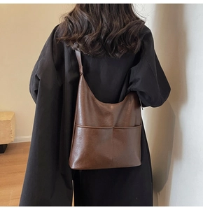Borsa a secchiello in finta pelle marrone con tasche frontali e cappotto nero invernale
