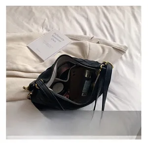 Vue détaillée de l'intérieur d'un grand sac cabas matelassé noir avec objets du quotidien