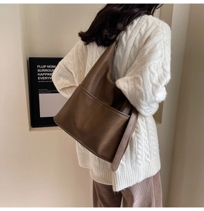 Dettaglio borsa shopper in pelle marrone scuro con trama vintage e tasche frontali