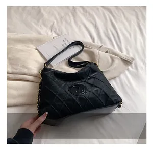 Détail du cabas matelassé noir avec logo M métallique et bandoulière en chaîne