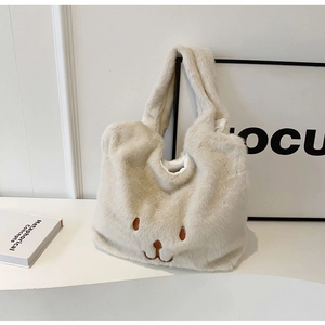 Dettaglio della borsa tote soffice bianco avorio con ricamo di viso di animale carino