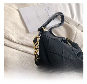 Détail de la bandoulière chaîne dorée réglable sur le sac cabas matelassé noir