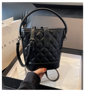 Close-up of quilted black bucket bag in a luxury gift box with elegant handles