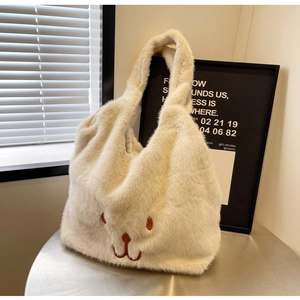Dettaglio ravvicinato della borsa tote in peluche bianco crema con ricamo a coniglietto