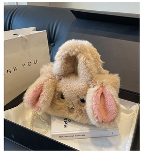 Detailed shot of beige plush rabbit bag with pink ears and a luxury pearl strap
