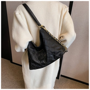 Détail du sac à bandoulière en cuir noir matelassé avec chaîne dorée et logo M