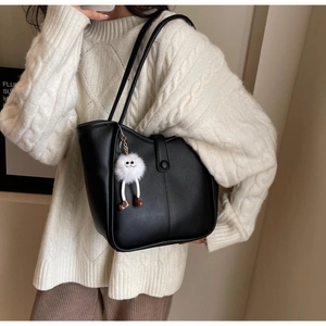 Dettaglio borsa tote nera con chiusura magnetica e ciondolo in peluche morbido