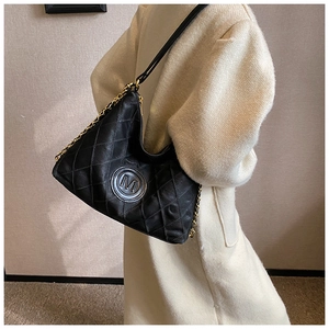 Détail du sac cabas en cuir matelassé noir avec logo M doré et bandoulière chaîne