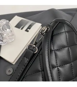 Close-up of black quilted leather bucket bag featuring polished gunmetal hardware detail