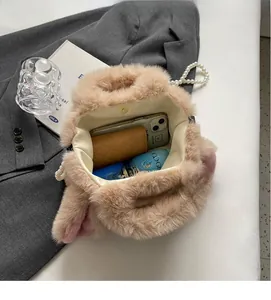 Interior view of plush beige faux fur handbag showing spacious storage for daily essentials