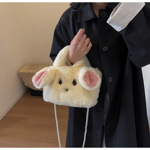 Detail view of white plush rabbit bag with soft faux fur texture and elegant pearl strap