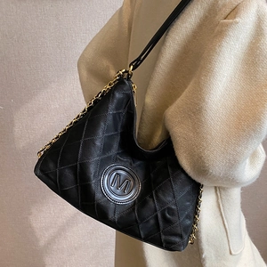 Sac fourre-tout noir matelassé avec chaîne dorée et logo M sur pull en maille