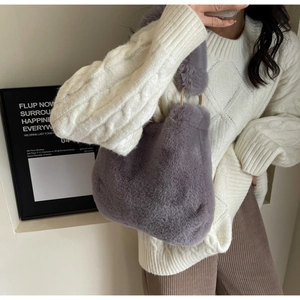 Detail of dark purple plush shoulder bag with metal ring buckle shown on a model