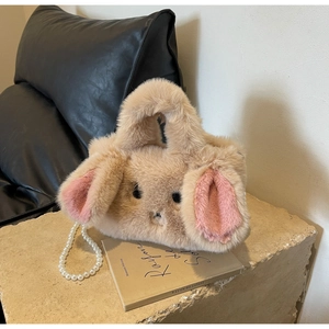 Detail of plush rabbit handbag with pink inner ears and elegant faux pearl chain strap