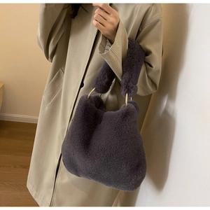 Detail of dark grey faux fur tote bag with thick handles and gold metal ring connectors