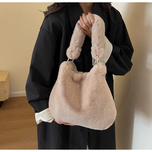Close-up of plush faux fur texture and golden metal ring hardware on the handbag