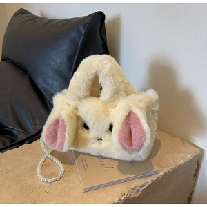 Detailed macro view of a beige plush bunny handbag featuring decorative pearl chain strap