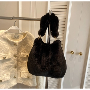 Detail of black faux fur tote bag showing plush texture and gold ring handle attachments