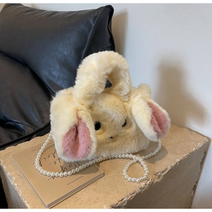 Detail of soft faux rabbit fur handbag with cute pink ears and elegant pearl strap