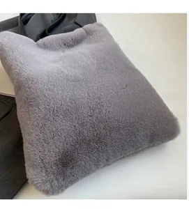 Gros plan sur le cabas en peluche gris clair avec anses en cuir synthétique noir
