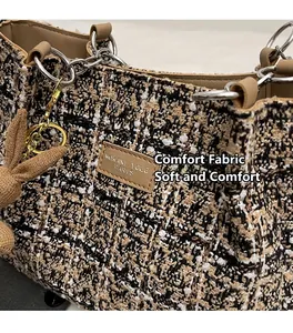 Detail of tweed fabric texture with metal chain strap and cute rabbit pendant on tote bag