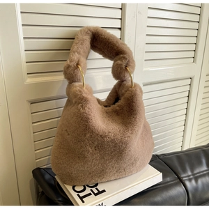 Detail of soft camel faux fur texture and large gold metal rings on a winter handbag