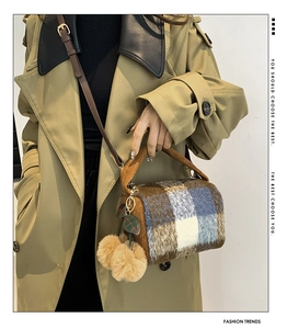 Detail of plaid tweed Boston bag with corduroy handles and large fuzzy pompom charm