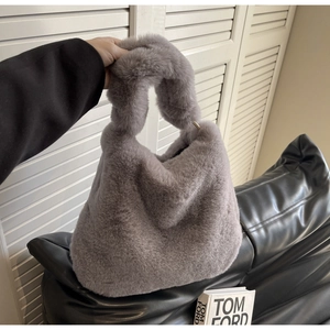Close-up of deep gray faux fur handbag showing its soft plush texture and round silhouette