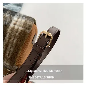 Détail de la bandoulière réglable en cuir avec boucle dorée sur le sac Boston