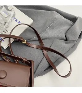 Detail of dark brown leather saddle bag featuring adjustable strap and buckle closure