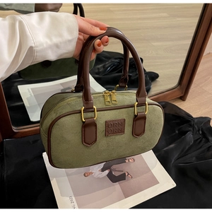 Dettaglio borsa Boston vintage in pelle scamosciata verde con doppi manici marroni