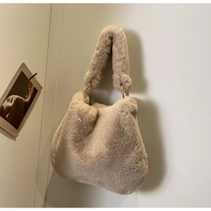Detailed macro view of soft khaki faux fur texture and gold metal ring hardware on handbag