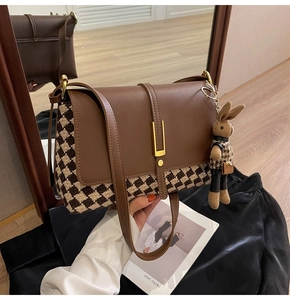 Detail of vintage tote bag with houndstooth fabric and gold metal clasp closure