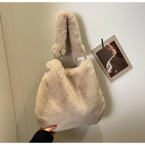Detail of soft cream faux fur tote bag with golden metal ring and thick plush handle