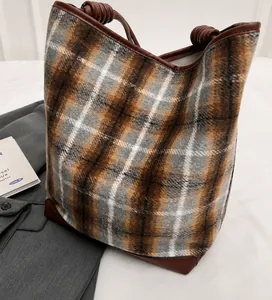 Detail der Vintage-Plaid-Tragetasche mit gewebtem Wollstoff und gedrehten Seilgriffen
