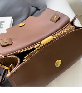 Detailed close-up of premium golden metal zipper and smooth hardware on brown leather bag