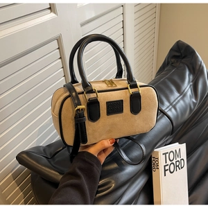 Dettaglio borsa Boston con texture effetto montone, finiture in pelle nera e zip dorate