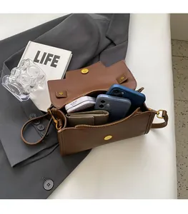 Interior view of brown leather crossbody bag showing space for two phones and a wallet