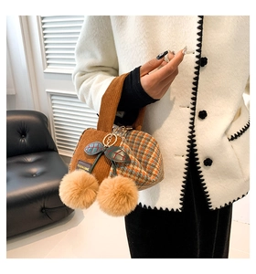 Detail of cherry-shaped corduroy Boston bag with plush pom-poms and leaf accent